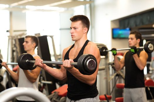 sport, fitness, lifestyle and people concept - group of men with barbells in gym