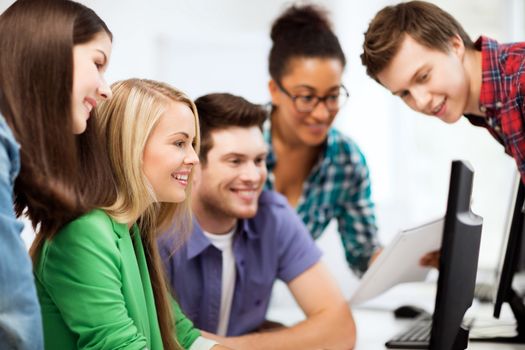 education concept - students looking at computer monitor at school