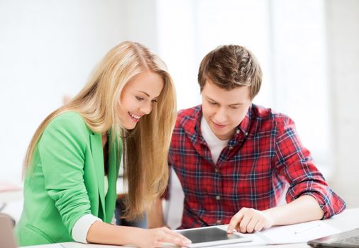 education, technology and internet - students looking at tablet pc at school