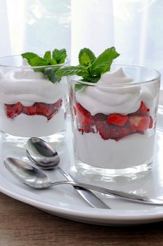 Strawberry and mascarpone cheese parfait in glasses with spoons 