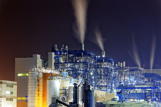 Power station with a steam cloud blown by the wind in a cold starry winter night