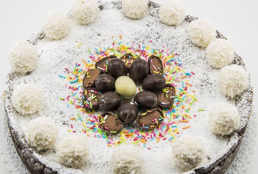 Easter cake with ricotta and chocolate decorated with chocolate eggs and powdered sugar