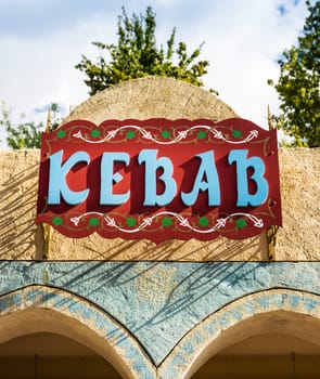 Sign decorated and painted with raised letters that form the word "kebab".