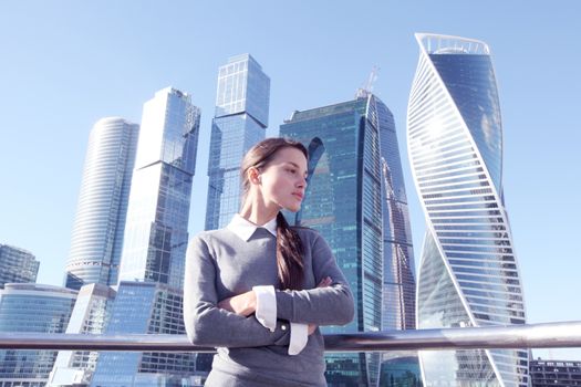 Young beautiful businesswoman outdoors at skyscraper background