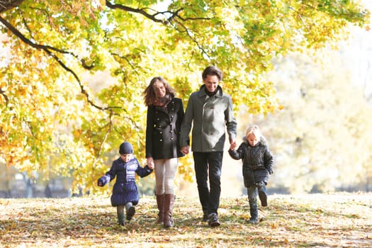 Portrait of family with children walking in autumn park