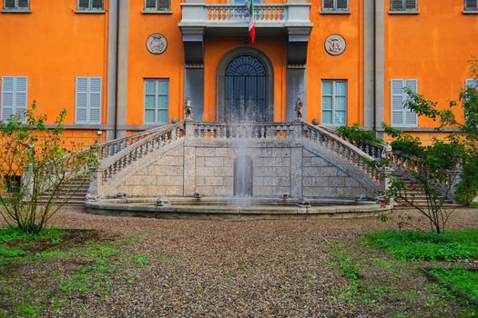 Beautiful view of the fountain and the staircase entrance of a palace in Pavia, Italy