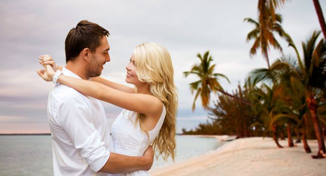 summer holidays, people, love, travel and dating concept - happy couple hugging over tropical beach background