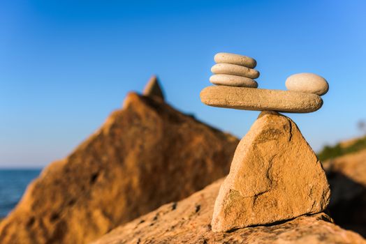 Balanced stack of pebbles on the stony seashore