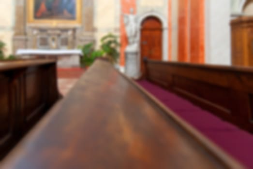 Rows of wooden church benches without anybody from close, blur abstract background