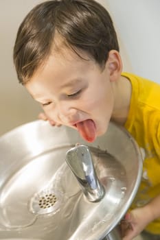 Mixed Race Boy Drinking From the Fresh Water Fountain.