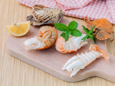 Boiled Flathead lobster, Lobster Moreton Bay bug, Oriental flathead lobster with herbs and spices  sauce on wooden background.