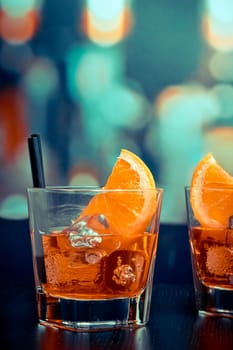 glasses of spritz aperitif aperol cocktail with orange slices and ice cubes on bar table, pop style atmosphere background, lounge bar concept