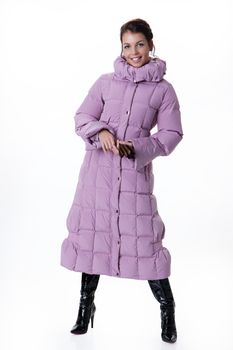 Young beautiful woman in fashionable winter warm clothing on isolated studio background