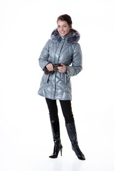 Young beautiful woman in fashionable winter warm clothing on isolated studio background