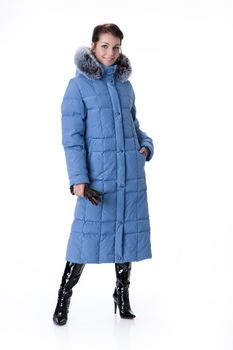 Young beautiful woman in fashionable winter warm clothing on isolated studio background