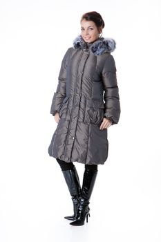 Young beautiful woman in fashionable winter warm clothing on isolated studio background