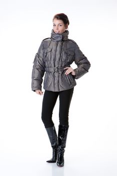 Young beautiful woman in fashionable winter warm clothing on isolated studio background