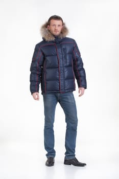 Young man in fashionable winter clothing on isolated studio background