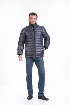 Young man in fashionable winter clothing on isolated studio background