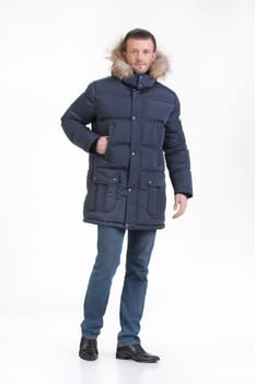 Young man in fashionable winter clothing on isolated studio background