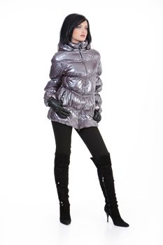 Young beautiful woman in fashionable winter warm clothing on isolated studio background