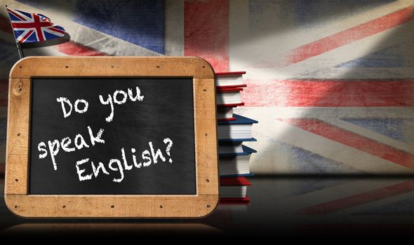 Blackboard with wooden frame and text Do you speak english? A stack of books on a wall with Uk flag