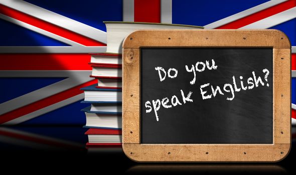 Blackboard with wooden frame and text Do you speak english? A stack of books on a wall with Uk flag.