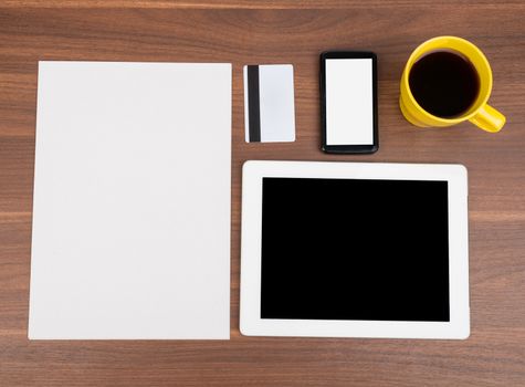 Blank paper with smartphone and blank card on wooden table