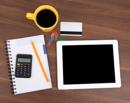 Blank copybook with tablet and calculator on wooden table