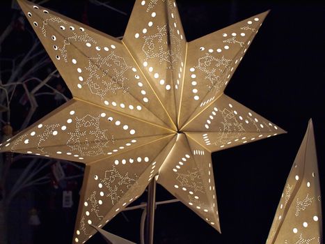 White glittering beautiful handmade star shaped Christmas decoration with dark background          