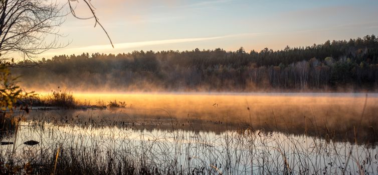 Morning sun rise revealing light fog on a Northern Ontario cottage lake.