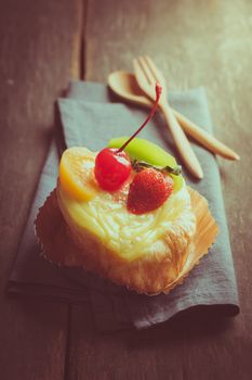 Fruit danish pastry on wood table in morning time with film filter effect