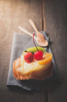 Fruit danish pastry on wood table in morning time with film filter effect