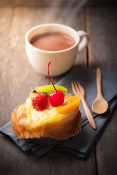 Fruit danish pastry with hot chocolate on wood table with morning scene
