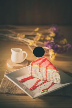 Rainbow crepe cake with black label on top in afternoon low key scene
