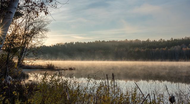 Morning sun reveals fog on a lake in Northern Ontario, Canada.