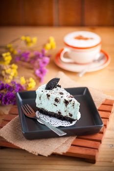 Peppermint with chocolate cookie cheese cake and hot cappuccino at cafe in afternoon time