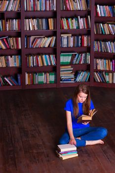 A girl sits on the floor in the library