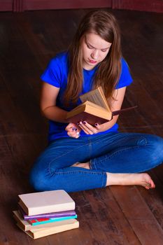 A girl sits on the floor in the library