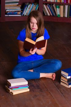 A girl sits on the floor in the library