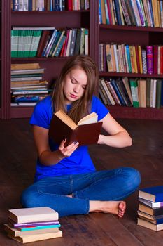 A girl sits on the floor in the library