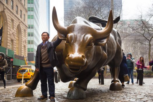 NEW YORK CITY - MAR 26: The landmark Charging Bull in Lower Manhattan represents aggressive financial optimism and prosperity March 26, 2015 in New York, NY, United States of America.