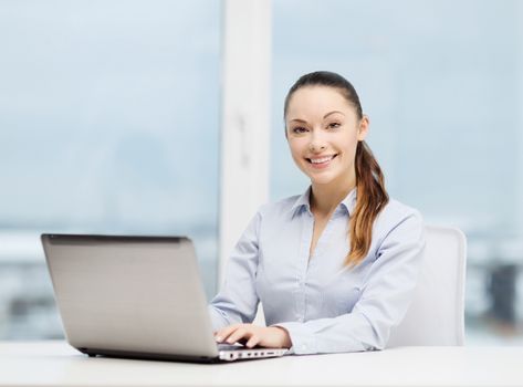 business and technology concept - businesswoman with laptop in office