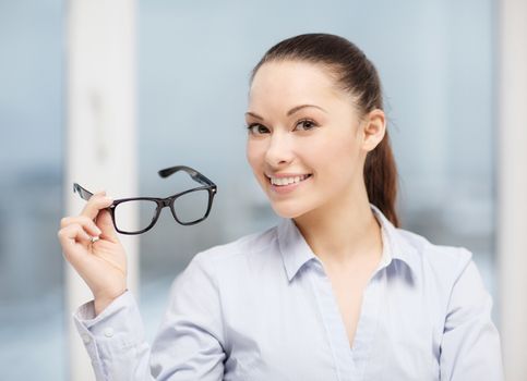 business and education concept - smiling businesswoman with eyeglasses