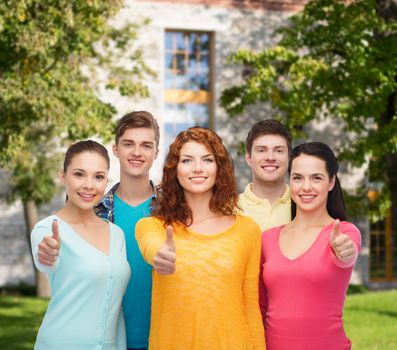 friendship, education, summer vacation and people concept - group of smiling teenagers showing thumbs up over campus background