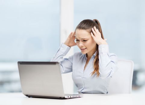 business, office and technology concept - stressed businesswoman with laptop at work