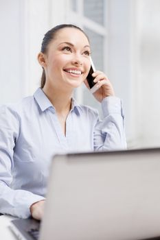 office, business and technology concept - smiling businesswoman with laptop computer and smartphone