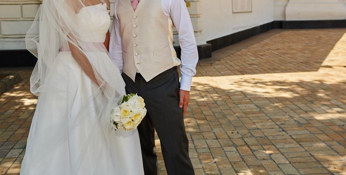 Elegant bride and groom posing together outdoors on a wedding day