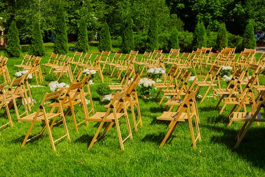 Rows of brown folding chairs from an outdoor wedding