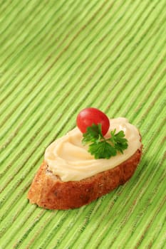 Slice of bread roll and creamy cheese spread